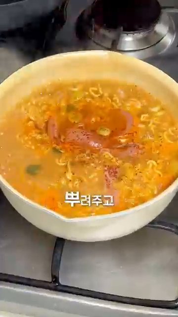 완성된 부대찌개 라면을 그릇에 담고, 한 젓가락 푹 떠서 맛있게 먹습니다.
