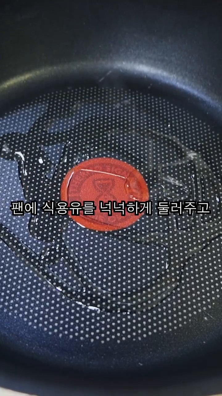 팬에 식용유를 넉넉히 두르고, 준비한 냉동만두를 가위로 잘라서 올립니다.