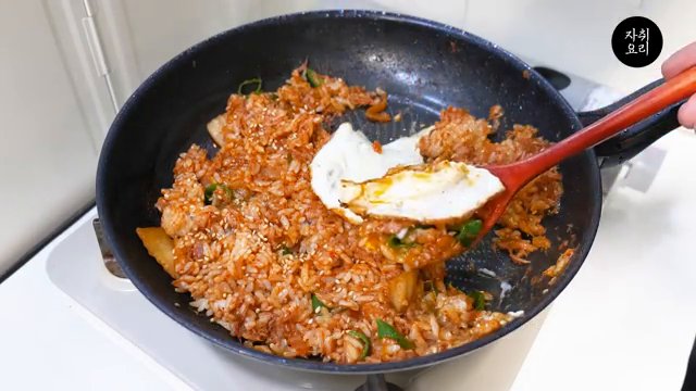 볶아진 밥 위에 계란 프라이를 올리고, 참기름과 통깨를 뿌리면 완성입니다.