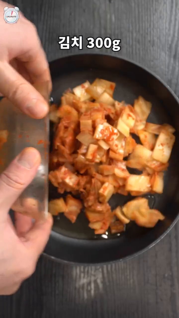 팬에 식용유를 두르고, 잘게 썬 김치와 대파를 넣고 볶습니다.