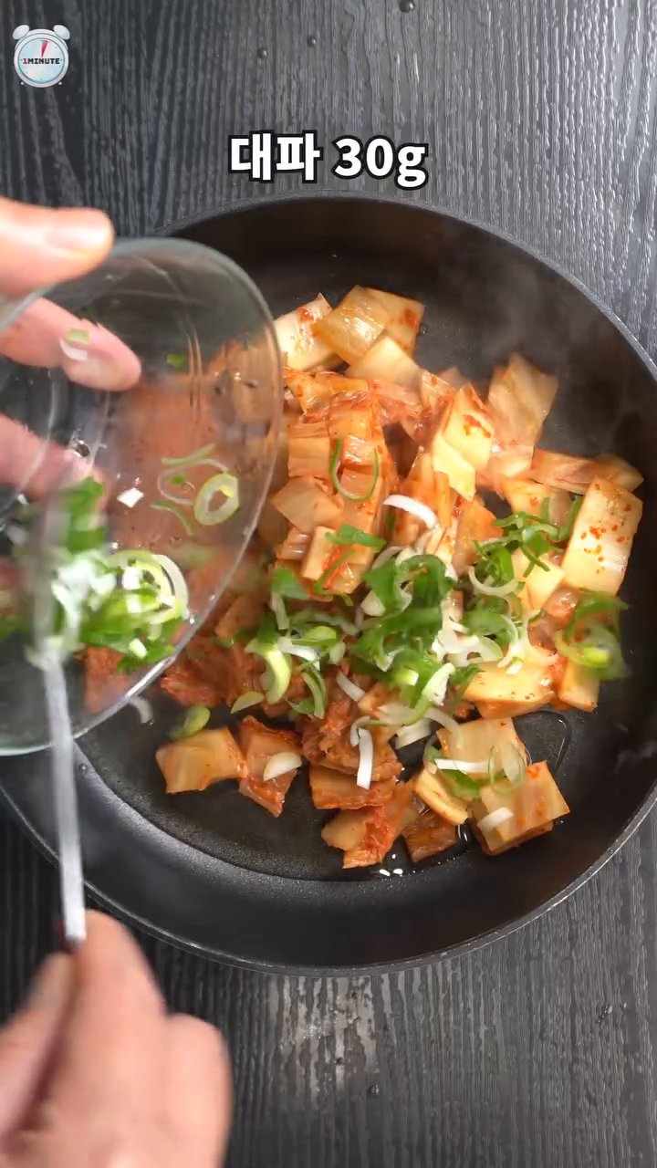 볶은 김치에 물, 고추장, 굴소스, 다진 마늘, 고춧가루, 설탕을 넣고 끓입니다.
