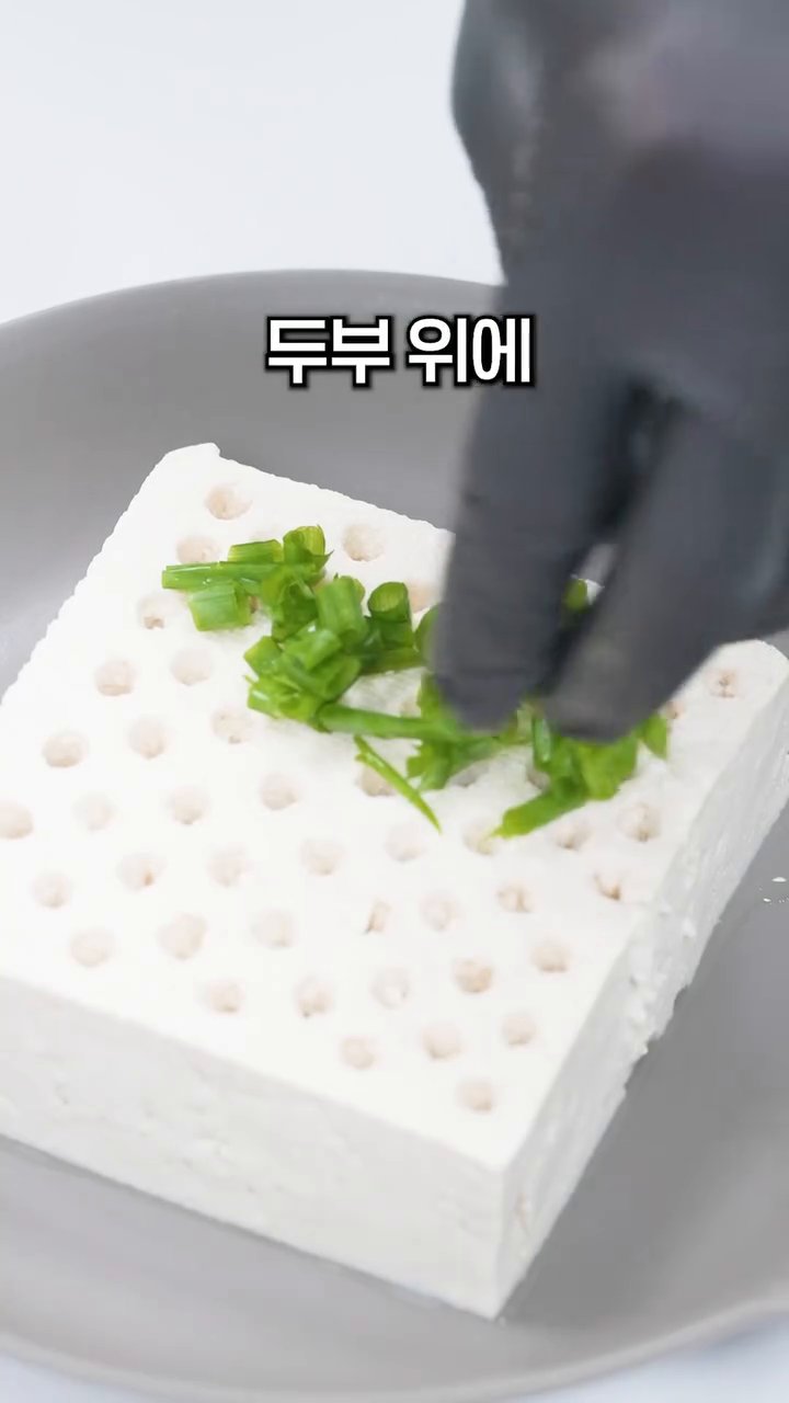 구멍이 뚫린 두부 위에 쪽파, 다진마늘 0.5스푼, 고춧가루 0.5스푼을 얹어줍니다.