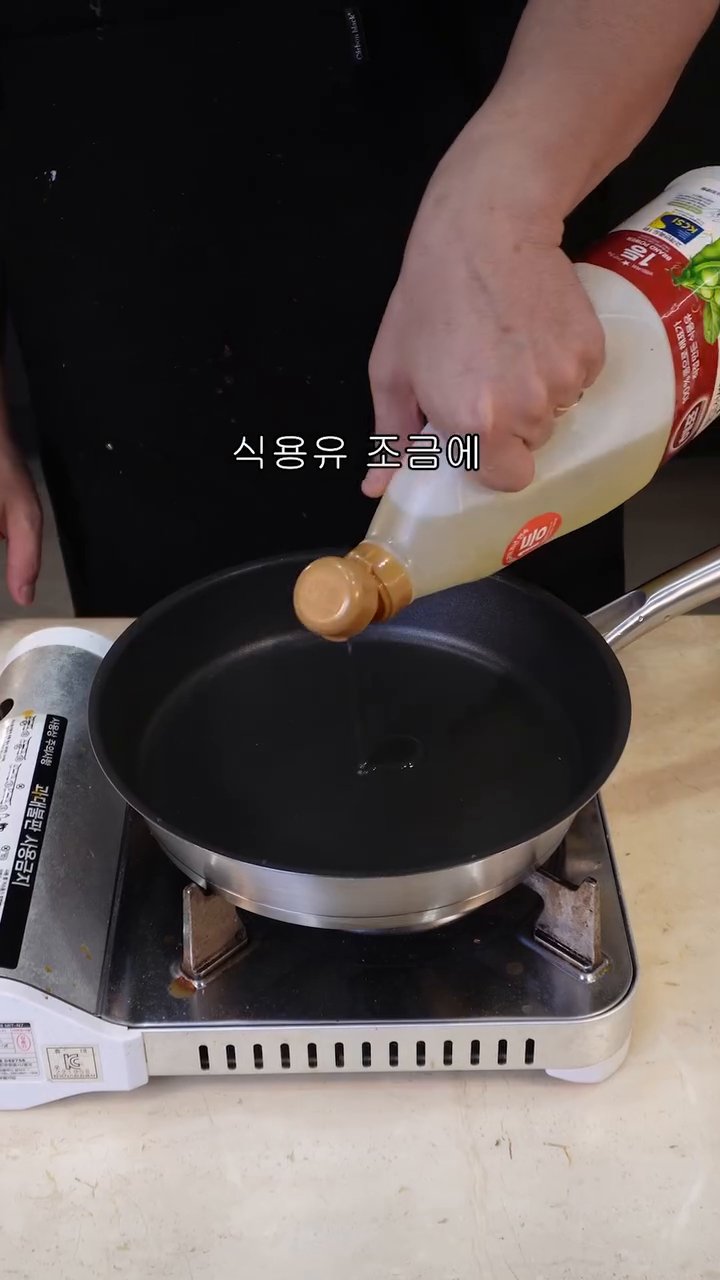 팬에 식용유를 조금 두르고 으깬 스팸과 계란 2개를 넣습니다.