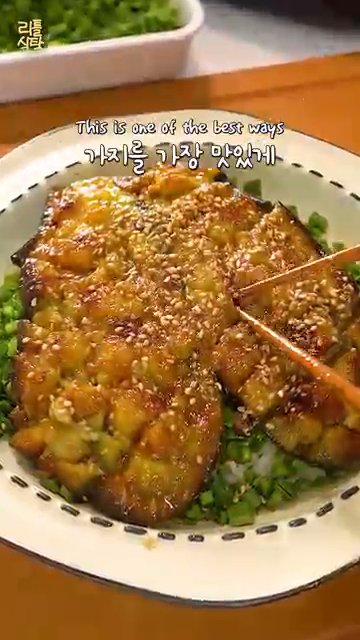 가지를 반으로 잘라 가운데에 칼집을 내고 꼭지를 자릅니다.
