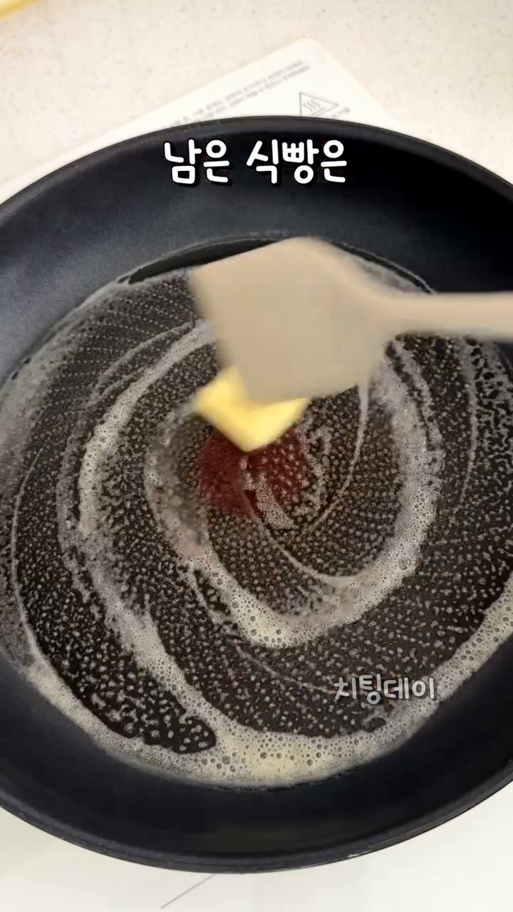 남은 식빵을 버터를 녹인 팬에 올리고 중앙에 계란을 넣어주세요.